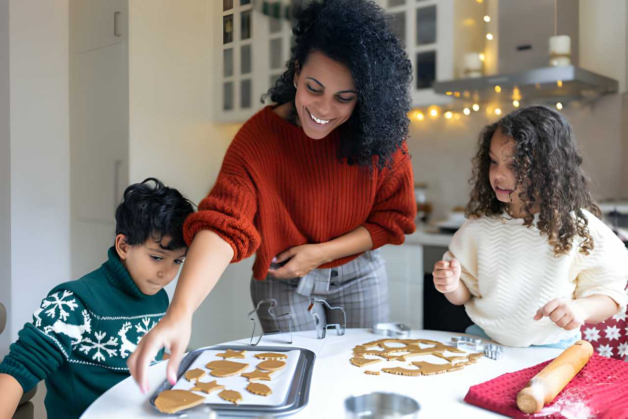 Sœur et frère faisant des biscuits au pain d’épices de noël avec une mère